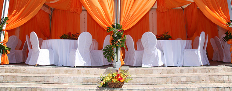Carpas de color naranja y mesas blancas