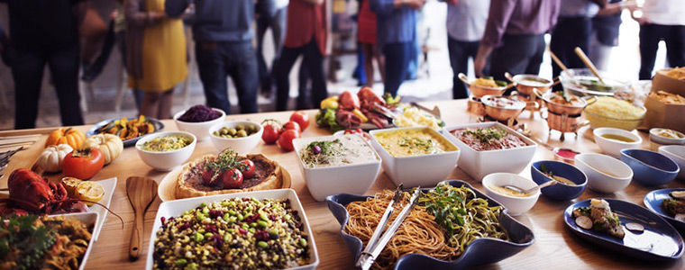 Personas y alimentos en un catering económico tipo bufet