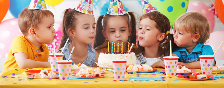 Niños felices con pastel, chuches y globos en la fiesta