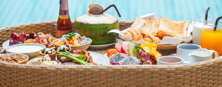 Bandeja flotante de catering con alimentos y frutas en la piscina